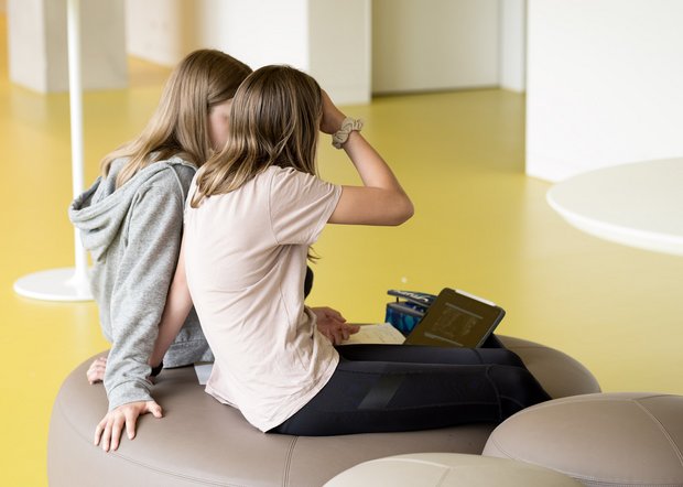Mädchen diskutieren im Schulgang über eine Analyse von Filmmusik